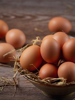 Eggs in cups on burlap with dry grass.